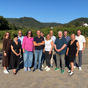 Gruppenbild der Kommissionsmitglieder, im Hintergrund Berge und blauer Himmel