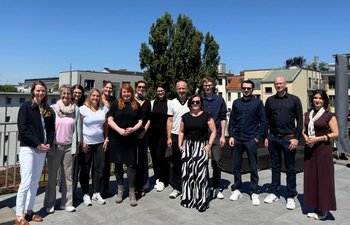 Gruppenbild der Kommission, blauer Himmel im Hintergrund